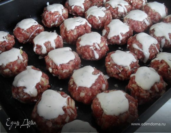 Рис отварить.Капусту мелко пошинковать.Добавить в фарш отваренный рис,капусту,яйцо,соль,перец,мелко порезанный лук.Сформировать небольшие котлетки.Выкладывать котлетки на смазанный маслом противень (чуть-чуть смазанный).Для соуса смешать сметану, кетчуп, добавить зелень.Котлетки полить соусом.Отправить в духовку разогретую до 200 градусов на 35-40 минут.