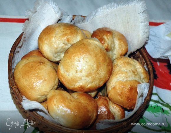 Из второй части раскатать прямоугольник. Размять масло, замешать в него сахар и корицу. Намазать эту начинку ложкой на тесто. Скатать в рулет и нарезать ломтиками шириной по 2 см. Выложить "улитки" на противень с пергаментом и дать им выстояться 20 мин.