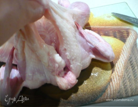 Курицу помыть, просушить. Приподняв кожицу на грудке (помогать себе ножом, но осторожно, чтобы не порезать кожицу), сделать кармашек. Начинить кармашек пряным маслом.  Остатками обмазать курицу. Лимон порезать пополам и положить внутрь курицы. 
