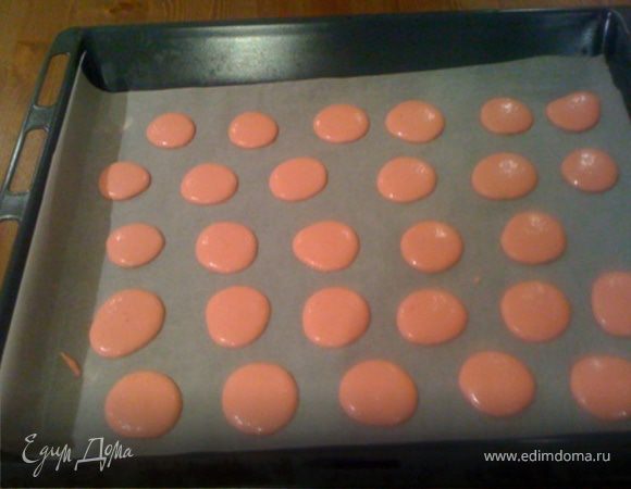 В глубокой посуде перемешать миндальную муку и пудру. Добавить остальные белки (45 гр.) и белково-сиропную массу. Хорошо вымешать, чтобы не было пузырьков воздуха. Противень выложить калькой. Чтобы она не елозила, я на противень капаю по углам  горошину безе. Наполнить массой шприц и выдавить кругляши диаметром ок. 2.5 см. Поднос с кругляшами побить снизу рукой, чтобы остатки воздуха вышли из теста. Дать кругляшам постоять около 60 мин. для того чтобы поверхность подсохла, образовалась корочка. Готово, когда при прикосновении не пристает. 
