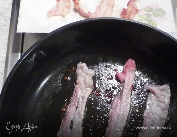 Тем временем на сковороде без масла обжарить бекон, выложить его на бумажное кухонное полотенце, чтобы жир стек.