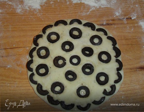 сверху выкладываем нарезанные кружочками маслины, и слегка вдавливаем их в тесто.Сверху лепешки смазываем оливковым маслом. 