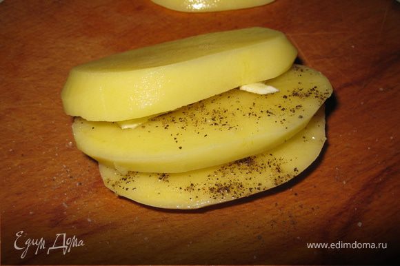 Каждую пластинку необходимо посолить, поперчить и переложить маленьким кусочком масла, формируя "первоначальный" вид картошки.