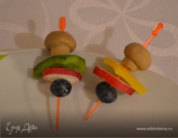 Нанизать на шпажку шампиньон, болгарский перец, вырезанный треугольником, кружочек редиски и ягодку черники