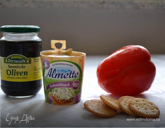 На крекеры выдавить сыр Альметте из шприца с фигурной насадкой. Из болгарского перца вырезать треугольнички удлиненной формы, выложить из на сыр в виде звездочек, добавить полуколечко из маслины и зелень петрушки