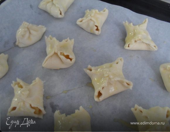 На серединку каждого квадратика положить по кусочку (1-3)ананаса.Края собрать сверху,защипить.Разложить конвертики на смазанный маслом лист пергамента, смазать взбитым яйцом.Выпекать в разогретой до 180 градусов духовке до золотистого цвета.Готовые конвертики посыпать сахарной пудрой.