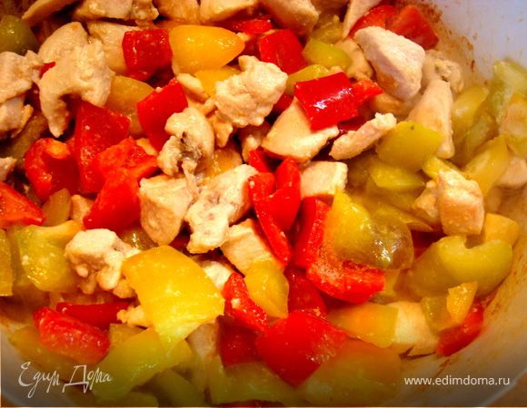 Обжарить в кастрюле на оливковом масле кусочки грудки вместе с луком. Добавить порезанный сладкий и острый перцы. Тушить 3 минуты.