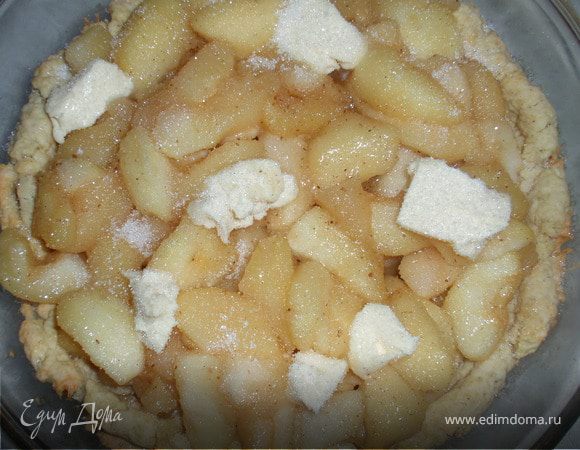 Тесто выкладываем в форму с высокими бортиками. Отправляем в духовку на 20 минут, выпекаем при температуре 200градусов. Затем на тесто выкладываем яблоки с сиропом, кусочки сливочного масла и посыпаем 1ст.л сахара.