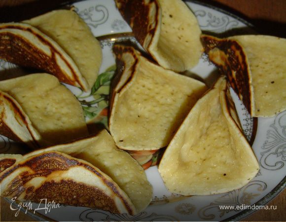 Блинчики нельзя передержать, иначе они станут очень хрупкими и будут ломаться. Выкладываем блинчики на доску и с одной стороны соединяем пальцами концы.