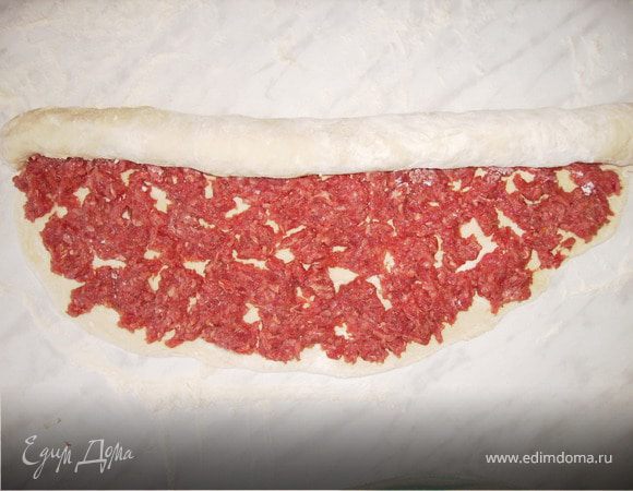 Замесить пельменное тесто, раскатать его и уложить на него тонким слоем фарш, предварительно посоленный и поперченный.Закрутить в рулет. 