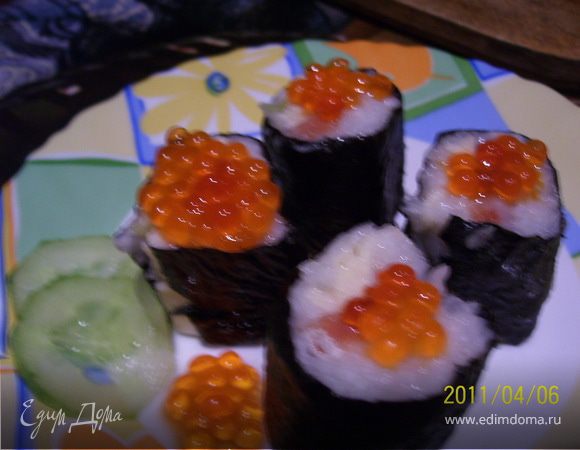 Положить обе половинки рулета рядом и одновременно разрезать их на три части. Украшаем красной икрой, подаем с соевым соусом.