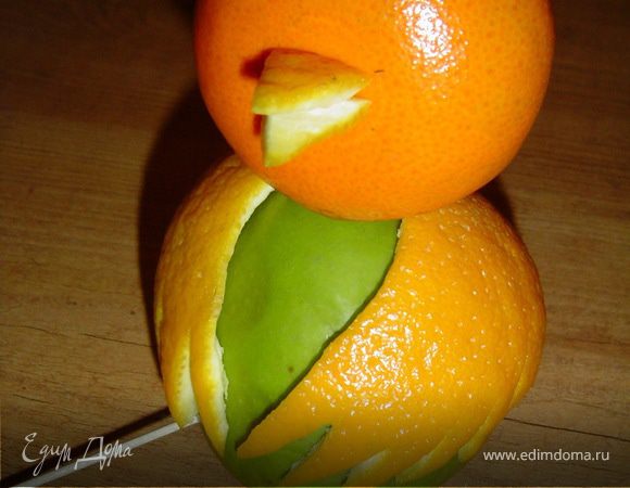 Из кожуры апельсина вырезаем два небольших треугольника,
ниже центра мандарина делаем небольшое отверстие и в него вставляем эти треугольники, тем самым получая клюв.