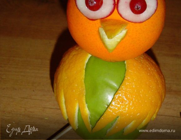 два кружочка зубочистками прикрепляем в центральной части мандарина,
в центре кружков из редиса крепим по ягоде клюквы - глаза готовы.
Чубчик можно вырезать из яблока, у меня - из кожи арбуза.