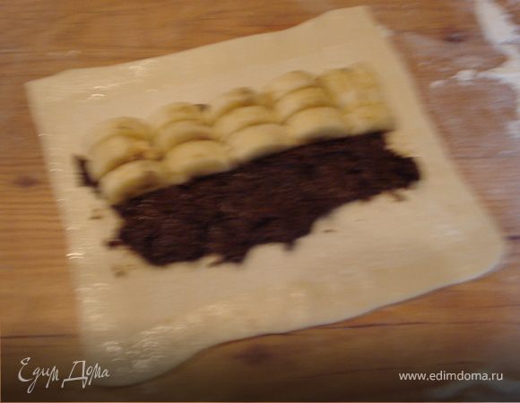 а сверху распределяем ломтики банана. Смазываем края прямоугольника яичным белком.