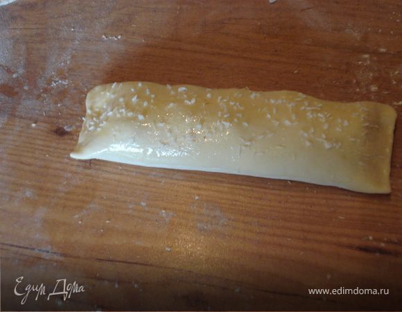 Сворачиваем рулетики, плотно прижав края. Рулетики смазываем желтком и посыпаем кокосовой стружкой.