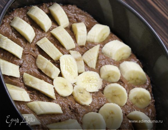 Выложить половину тесто в смазанную маслом форму.  Выложить часть бананов и залить оставшимся тестом.Нарезанные кусочками бананы положить сверху, слегка их вдавливая. 