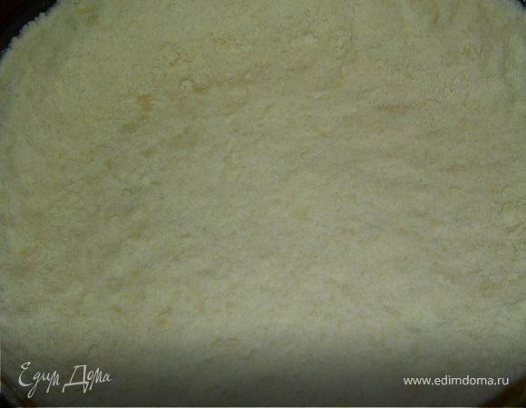Форму смазываем маслом и присыпаем мукой, затем 2/3 крошки высыпаем в форму и руками распределяем по форме прижимая, и формируем борта.