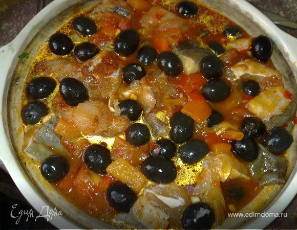 Запечь перцы в духовке под гридем до черных подпалин, положить в пакетик, дать немного полежать и остыть. Очистить от кожуры и нарезать кубиками. Смешать перец с нарезанными помидорами (так как зима, я покупаю готовые рубленные помидоры в собственном соку) и слить сюда же маринад из под рыбы. Солим-перчим если надо. На картофель сверху выкладываем получившуюся овощную массу, посыпаем половиной оливок, затем рыбу и вторую половину смеси и оливок. Добавить около 150 мл воды.  Накрыть крышкой и готовим 15-20 минут в предварительно разогретой до 200 духовке (я готовила дольше, т.к. долго керамическая кастрюля набирала тепло).