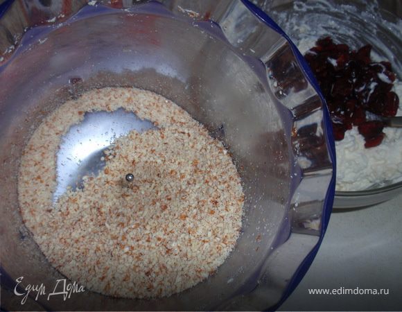 Размягченное сливочное масло перемешать с творогом. Добавить муку, разрыхлитель, ванильный сахар, сахар, клюкву и измельченный в процессоре миндаль.