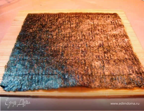 На специальную циновку выкладываем лист нори, 