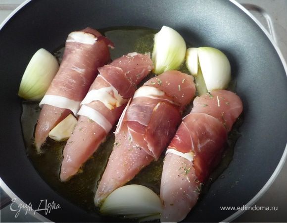 Лук режем на 4 части, чеснок - пополам. Разогреваем масло на сковороде, выкладываем лук и чеснок, затем куски филе. Обжариваем на среднем огне по 3 минуты с каждой 
стороны до золотистого цвета.