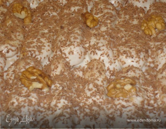 Сметану взбейте, постепенно добавляя сахарную пудру, в пышную устойчивую массу. Испеченные «пальчики» обмакните в крем и сложите в довольно глубокое блюдо рядами и слоями.
Сверху украсьте тертым шоколадом и дольками грецких орехов. Дайте постоять часов 8-10. Я делала с вечера, а утром можно есть. Приятного аппетита!!!
