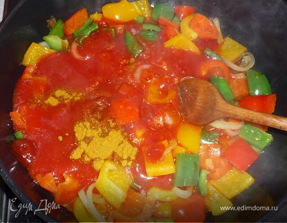 Добавить к перцу и луку томаты, кетчуп и карри и тушить на среднем огне 5 минут.  Посолить, поперчить, бросить щепотку сахара. Вмешать к овощам колбаски.