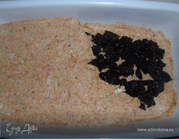 Положить половину фарша в прямоугольную форму. Выложить чернослив, затем оставшийся фарш. Накрыть форму.