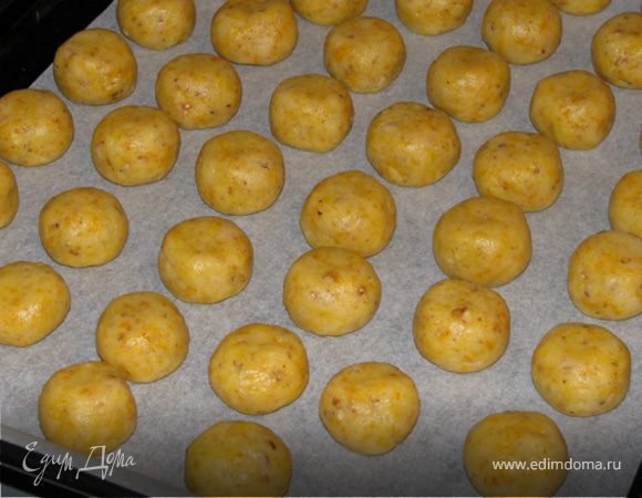 Из теста сформировать шарики размером чуть больше грецкого ореха, сверху слегка прижать и выложить на противень.
