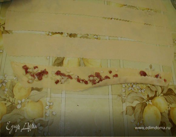 Ставим  кастрюлю с водой на газ. Смазываем  каждую полоску растительным маслом и равномерно раскладываем фарш и подгибаем низ на 0,3 см. 
