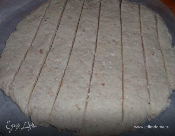 Смешиваем в миске две муки, добавляем овсяные хлопья, масло(нарезанное на мелкие кусочки), соль, соду. Вливаем холодное молоко и быстро замешиваем тесто. Ложим лепешку на противень посыпанный мукой, делаем на ней глубокие надрезы.