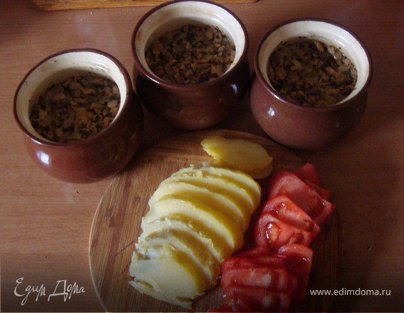 В горшочек выкладываем тушеную курицу, затем слой грибов.