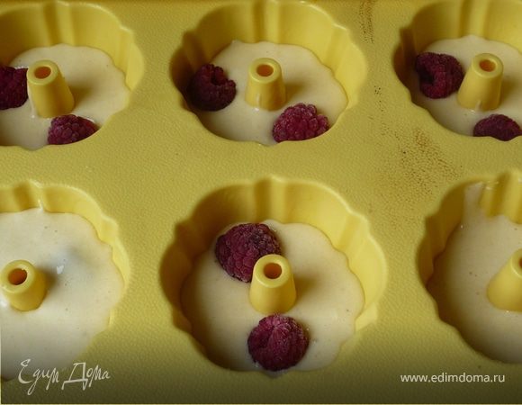 Разогреваем духовку до 200°C. 
Формы для маффиной смазываем сливочным маслом. Заполняем на 1/3 тестом, выкладываем несколько ягодок малины, сверху снова 
заливаем тестом (лучше не до конца, а оставить немного места сверху). Из данного количества теста получается 6 маффинов.