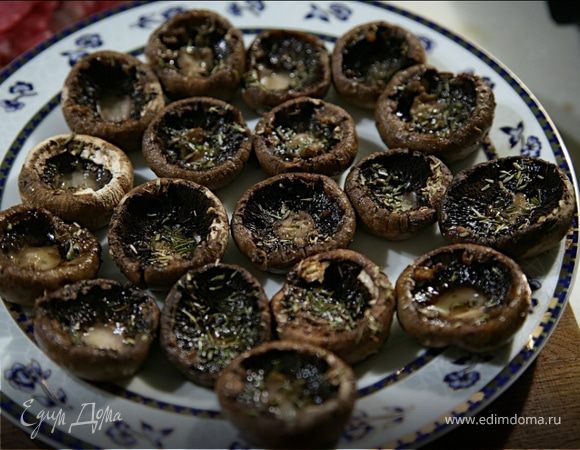 Протереть шампиньоны влажной тряпочкой,аккуратно отсоединить ножки от шляпок.Шляпки смазать со всех сторон маслом,приправить солью и праванскими травами изнутри.Выложить срезом вверх на протвень.Запекать в разогретой до 220 С 15 мин.