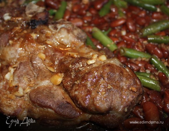 В сковороду положить мясо и вылить сок, который получился при запекании. Добавить к мясу стручковую и красную фасоль. В блендере измельчить один зубчик чеснока и миндаль. Добавить к фасоли, перемешать. Влить оставшийся маринад и запекать еще 15 минут в духовке. Приятного аппетита!