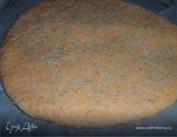 Формируем лепешки. Выкладываем на противень посыпанный мукой или застеленный бумагой. Посыпаем щедро кунжутом, немного вдавив его.