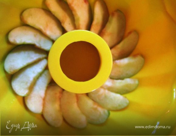 Форму смазываем маслом, выкладываем веером дольки яблок