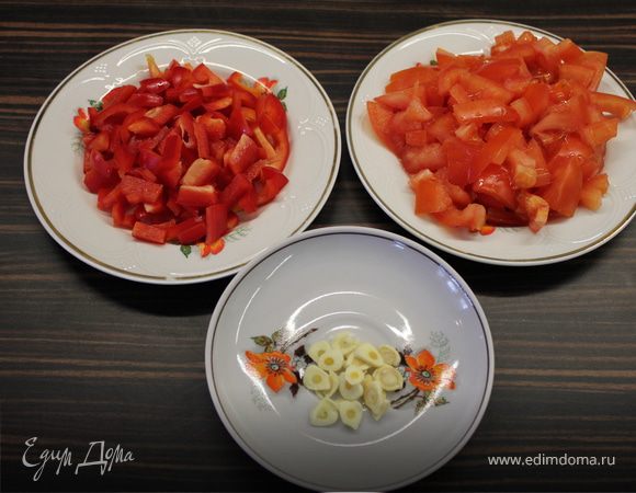 Тем временем нарезаем овощи кубиками и чеснок колесиками. 
На сковороду с разогретым маслом кидаем помидоры и томим, пока совсем не растают. 
Добавляем чеснок со сладким перцем и держим до готовности. Посолить.
