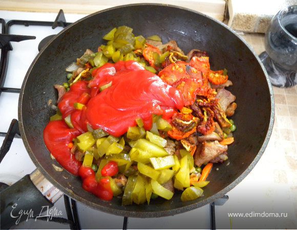 Добавляем помидоры и томатный соус (или пасту). Режем тонкими брусками огурец, мелко - чеснок. И еще оставляем минут на 10 тушиться.