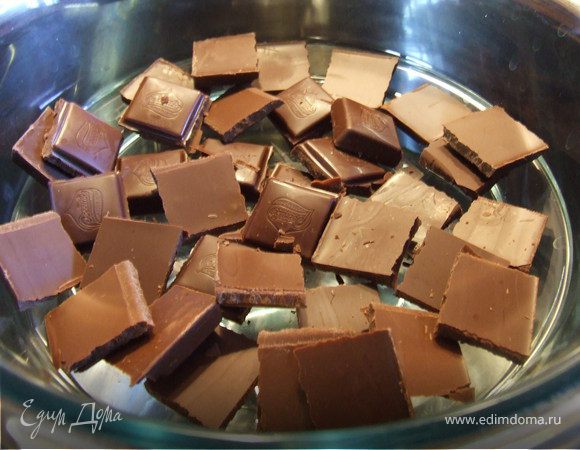 Вынуть готовый бисквит из духовки. Поставить форму на влажное полотенце, сверху накрыть сухим. Дать остыть. Остывший бисквит достать из формы и разрезать на 2-3 одинаковых по толщине коржа. Пропитать коржи водкой или любым алкоголем на ваш вкус.Два коржа промазать сверху кремом. Сложить их друг на друга и накрыть третьим коржом. Верхний корж промазывать не надо. Шоколад наломать на маленькие кусочки, сложить в огнеупорную посуду и поставить на кастрюлю с кипящей водой. 