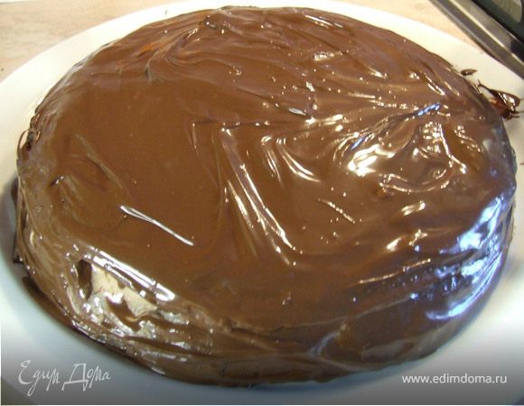 Когда шоколад растопится, обмазать им поверхность и бока торта. Поставить торт в холодильник минимум на 3 ч.
Посуду с остатками растопленного шоколада также поставить в холодильник. Когда шоколад застынет, соскрести его небольшим ножом. Украсить торт шоколадной стружкой.
