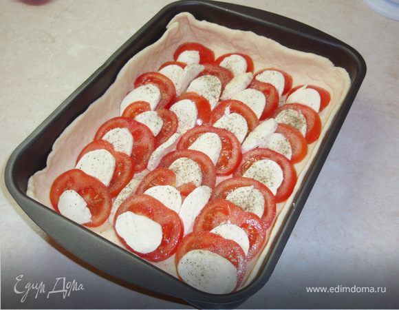 Раскатать тесто, поместить в форму, сделав небольшие бортики по бокам. Моцареллу и помидоры нарезать кружочками. Выложить, чередуя, моцареллу и помидоры на тесто. Посолить, поперчить, полить оливковым маслом.