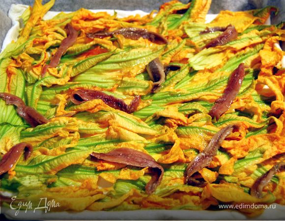 Теперь выложить анчоусы, равномерно распределяя по поверхности пиццы. 