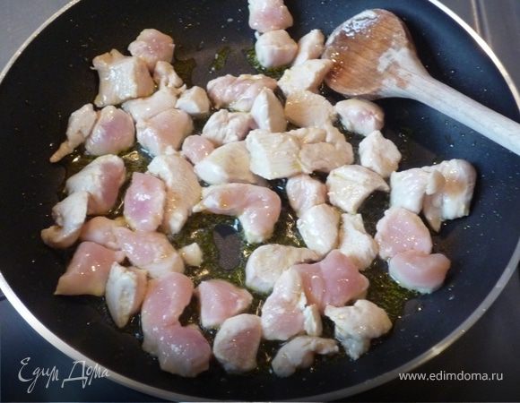 Разогреваем духовку до 200°C.
Тем временем режем на маленькие кусочки филе птицы. Лук мелко рубим. Перец чистим и режем небольшими кубиками.
Разогреваем в сковороде масло и обжариваем филе со всех сторон.