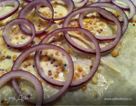 лаваш расвернуть на ровной поверхности, застеленной фольгой для выпекания. Намазать соусом. Луковичку порезать кольцами и выложить на лаваш.