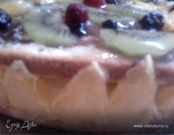 Готовый бисквит остудить и разрезать вдоль на две части, не снимая с нижнего блюда разъемной формы. Форму снова собрать и внутри вокруг стенок выложить треугольничками апельсинов. Полить корж сиропом (я смешала ингредиенты и довела до кипения). Затем выложить на корж крем (крема оставить совсем немного для верха), разровнять.