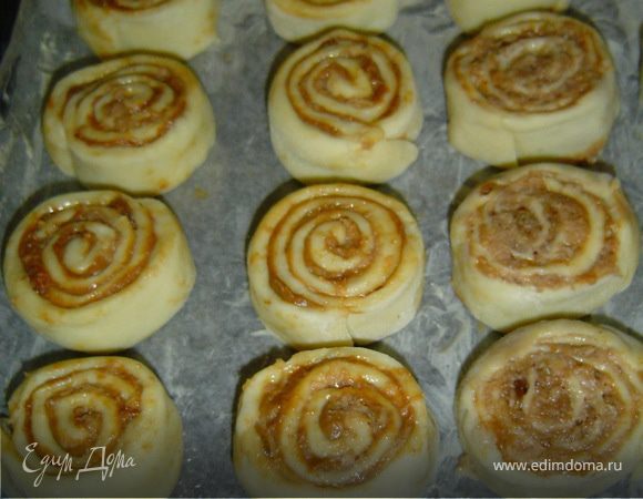 Форму , застелить промасленной бумагой, уложить булочки на небольшом расстоянии друг от друга срезами вверх,дать постоять минут 15, накрыв полотенцем, а затем смазать желтком и посыпать сахаром.