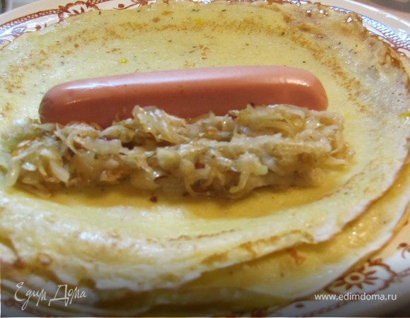 На готовые блины выкладываем капусту и сосиску.