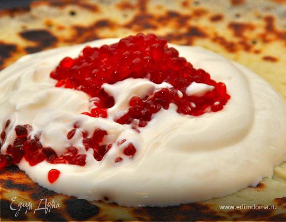 Теперь кладем наш хрустящий блинчик на тарелку, сверху выкладываем щедрую столовую ложку с горкой сметаны, потом чайную ложку красной икры топим в сметане и еще одну кладем сверху. Мне нравится икра кижуча или нерки, она не очень крупная и красивого алого цвета. Собираем блин с краев и наслаждаемся вкусом нежного теста, прохладой сметаны и пикантно солоноватым привкусом икры. Жизнь удалась!