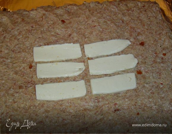 В центр ее выкладываем тонкие кусочки плавленого сыра.